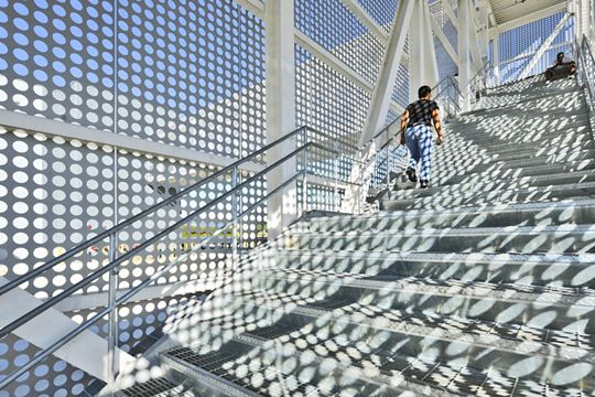 Close up view of McNICHOLS Perforated Metal covering a walkway while Bar Grating Stair Treads allow pedestrians to walk safely inside at a facility in Bessemer, AL