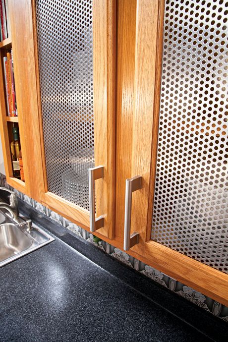 Close up view of McNICHOLS Round Hole Perforated Metal cabinet inserts in a kitchen in Woodmere, NY