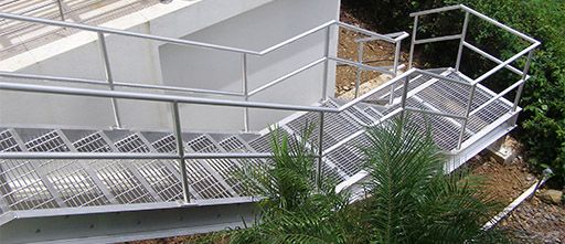 Photo of a staircase and railing with Bar Grating Stair Treads.